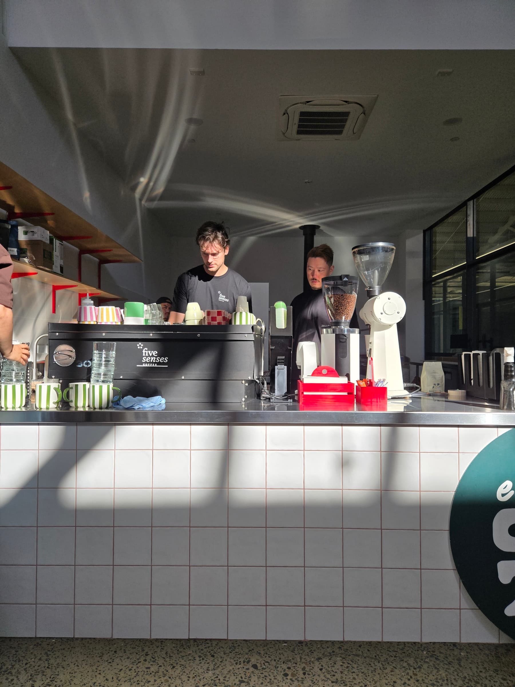 Eat Ozzo Marrickville counter — two baristas working the Five Senses espresso machine under the ozzo signage